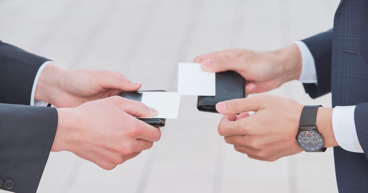 close up of hands exchanging business card