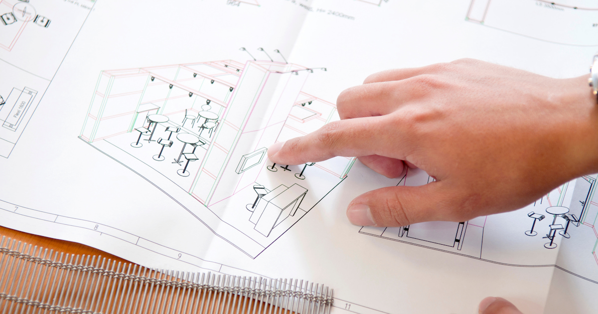 closeup of someone's hand pointing at plan for trade show booth design